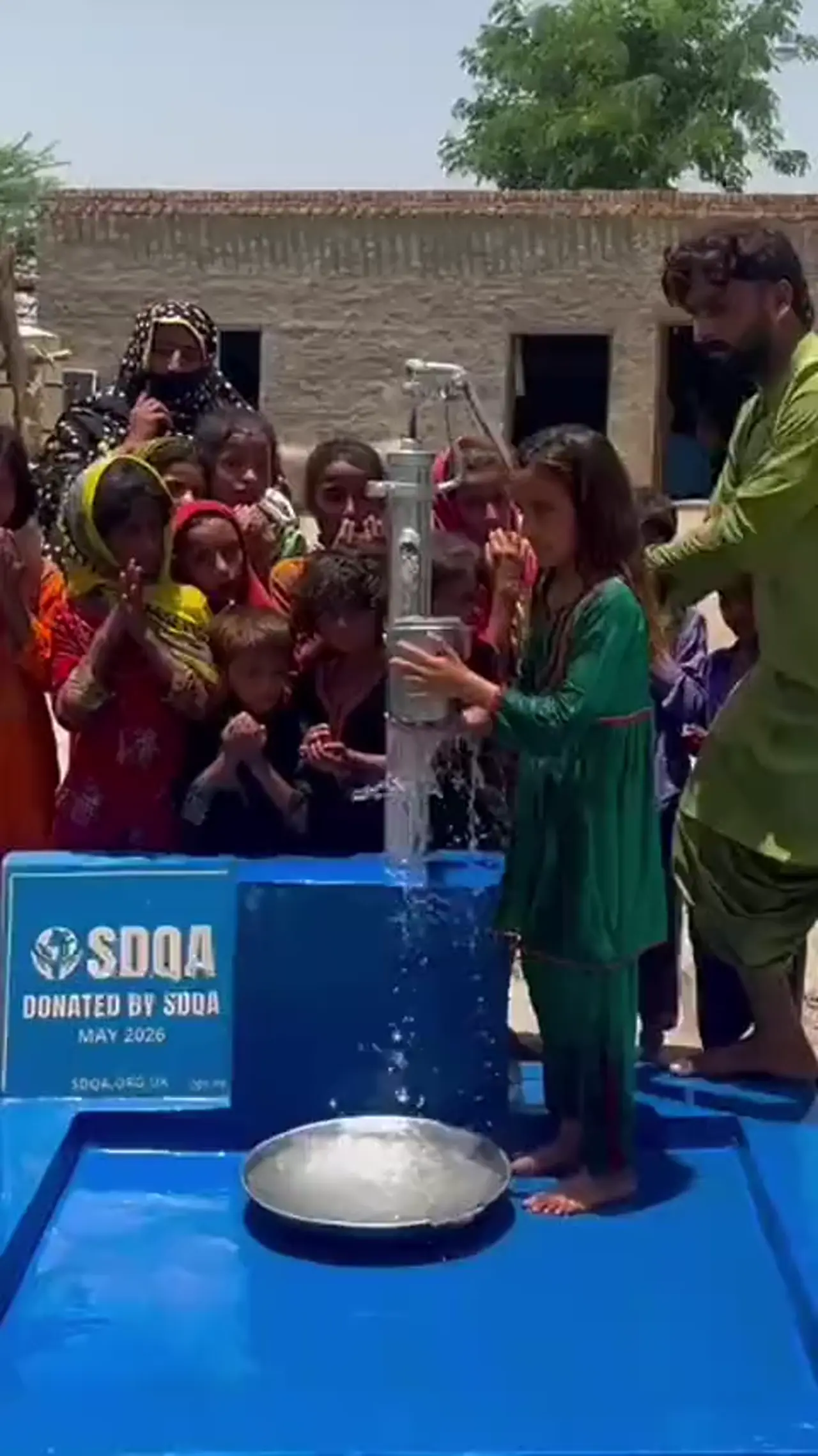Children gathered at a new SDQA hand pump in Pakistan